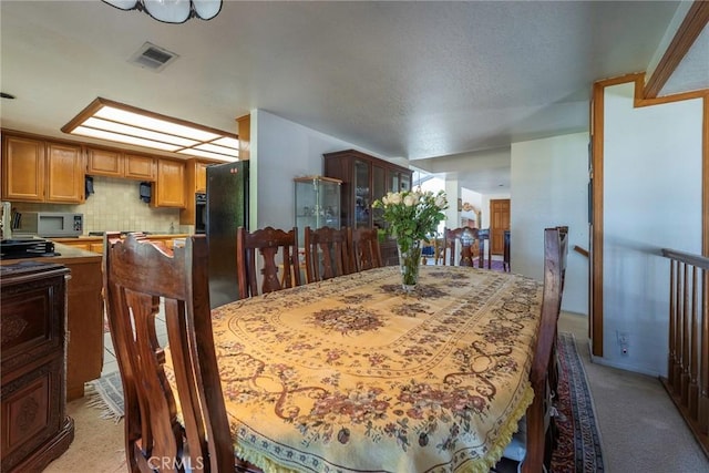 dining room with visible vents and light colored carpet