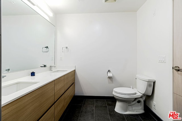 bathroom with tile patterned flooring, vanity, and toilet