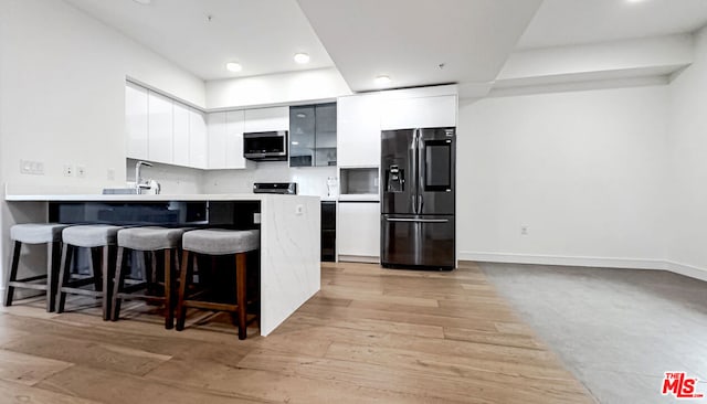 kitchen featuring white cabinets, light wood-type flooring, and stainless steel appliances