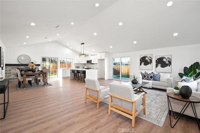 living room with light hardwood / wood-style floors and vaulted ceiling