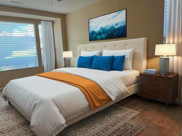 bedroom with dark wood-type flooring and multiple windows