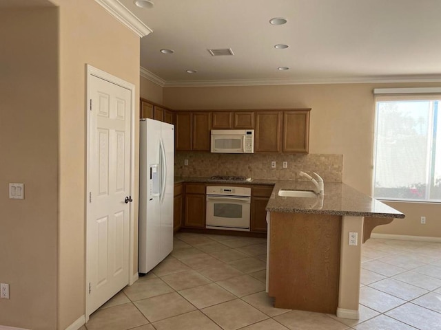 kitchen featuring white appliances, a kitchen breakfast bar, ornamental molding, kitchen peninsula, and light tile patterned floors