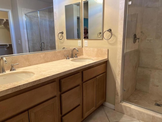 bathroom featuring a shower with shower door, vanity, and tile patterned flooring