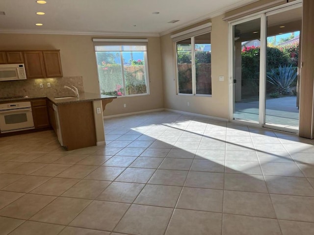 kitchen with backsplash, kitchen peninsula, light tile patterned flooring, white appliances, and ornamental molding