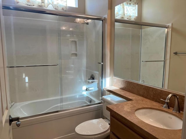 full bathroom with toilet, enclosed tub / shower combo, and vanity