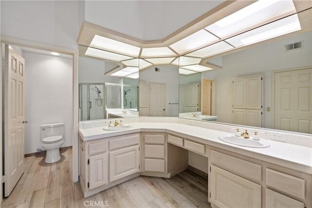 324 Sundance Cir, Palm Desert, CA 92211 - bathroom with hardwood / wood-style floors, vanity, toilet, and a shower with shower door