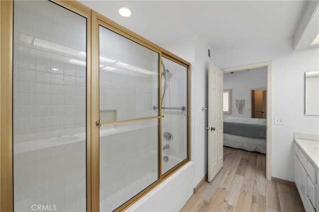324 Sundance Cir, Palm Desert, CA 92211 - bathroom with hardwood / wood-style floors, vanity, and shower / bath combination with glass door