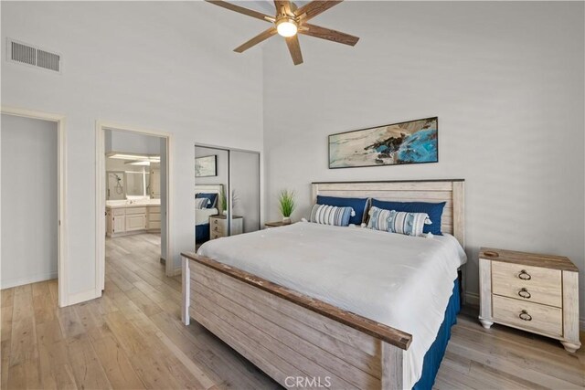 324 Sundance Cir, Palm Desert, CA 92211 - bedroom featuring a closet, connected bathroom, ceiling fan, and light hardwood / wood-style flooring