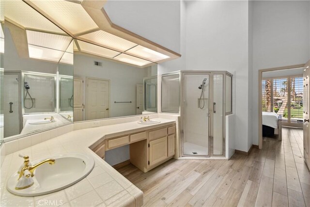 324 Sundance Cir, Palm Desert, CA 92211 - bathroom with hardwood / wood-style floors, vanity, a shower with door, and a high ceiling