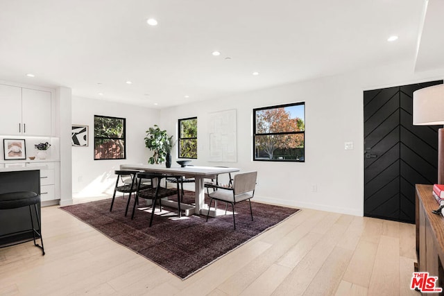 dining area featuring a barn door and light wood-type flooring