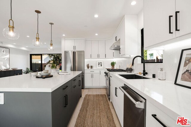 kitchen with white cabinets, pendant lighting, a kitchen island, and high quality appliances