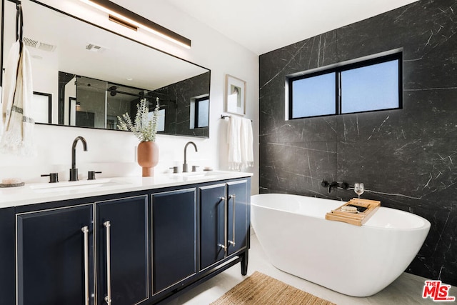 bathroom featuring a bathing tub, vanity, and tile walls