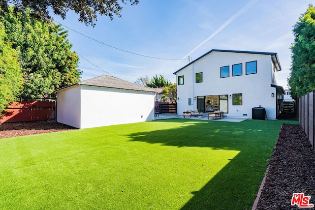 back of house with a yard, an outdoor structure, central AC unit, and a patio area