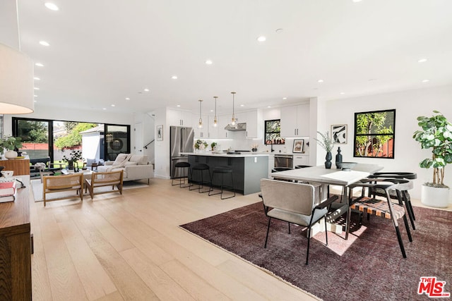 dining area with plenty of natural light and light hardwood / wood-style flooring