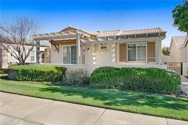 mediterranean / spanish-style home featuring a front yard and a pergola