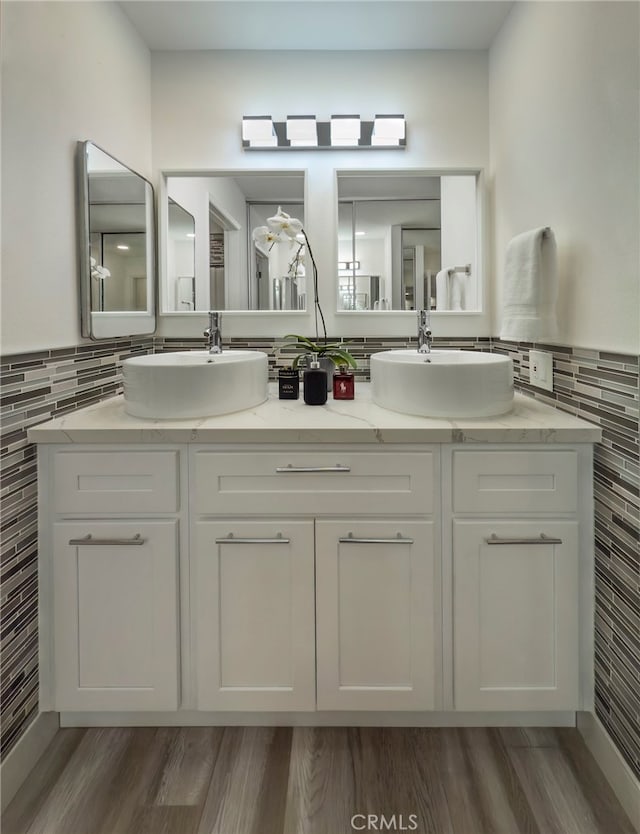 bathroom featuring backsplash, vanity, and wood-type flooring