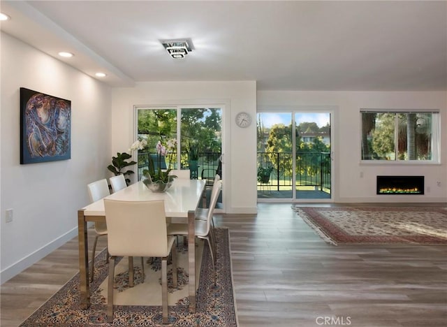 dining space with recessed lighting, baseboards, a healthy amount of sunlight, and wood finished floors