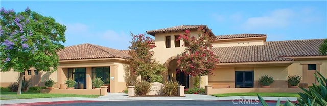 rear view of house with a tiled roof and stucco siding