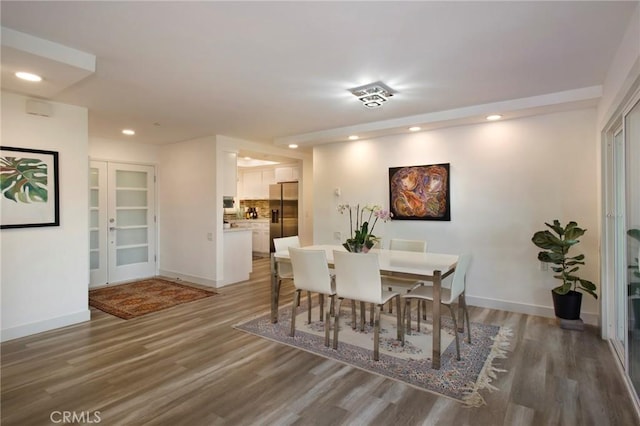 dining space with recessed lighting, baseboards, and wood finished floors