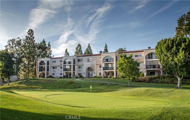 view of home's community featuring a lawn and view of golf course