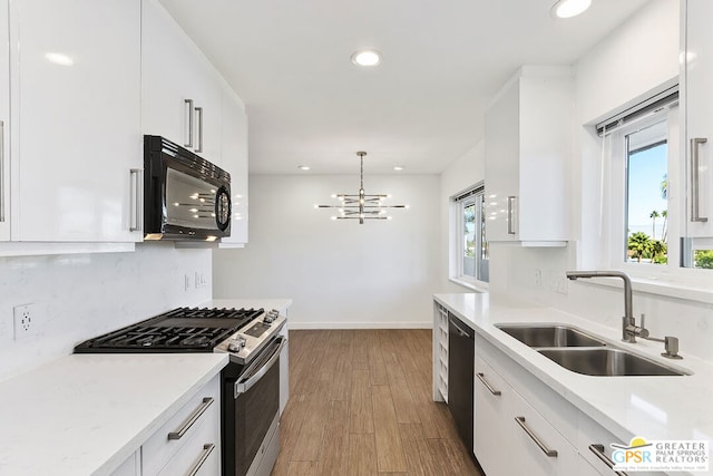 kitchen with white cabinets, sink, a wealth of natural light, and black appliances