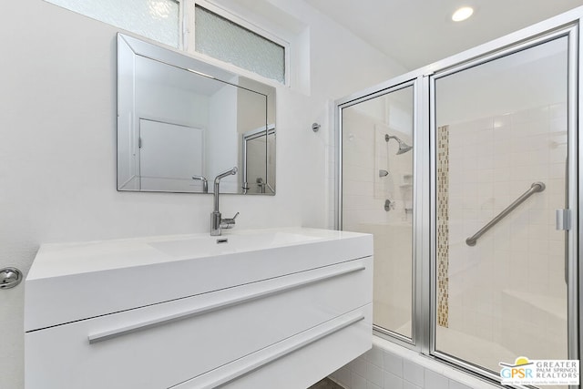 bathroom featuring vanity and a shower with shower door