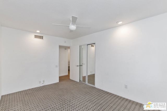 carpeted spare room featuring ceiling fan