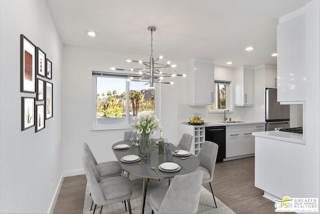 dining area featuring a notable chandelier, a wealth of natural light, dark wood-type flooring, and sink