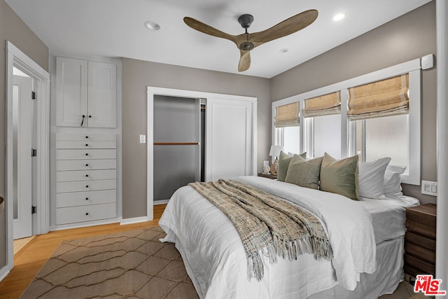 bedroom featuring ceiling fan, light wood-type flooring, and a closet