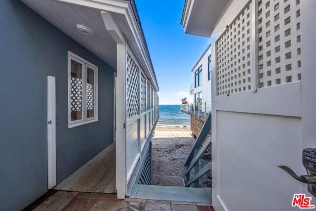 exterior space with a water view and a beach view