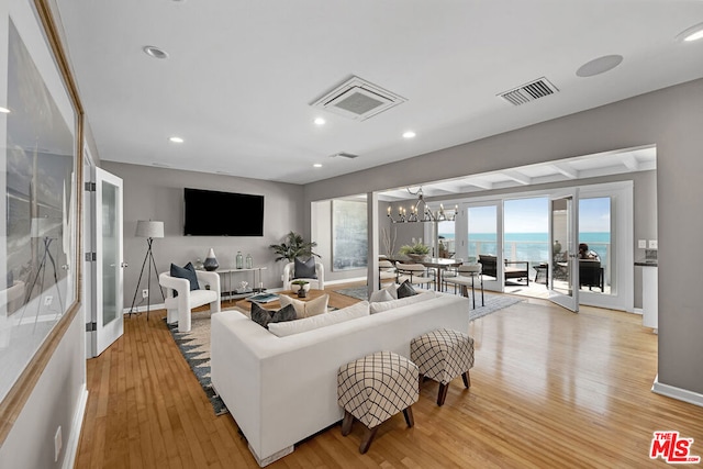 living room featuring a notable chandelier and light wood-type flooring