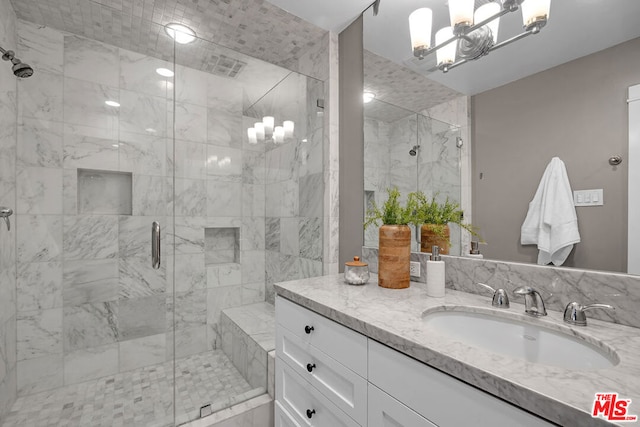 bathroom with vanity, an enclosed shower, and an inviting chandelier