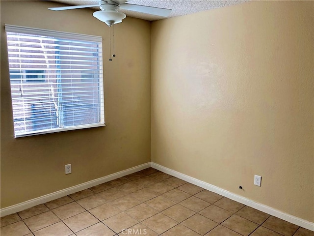 tiled spare room featuring ceiling fan and a textured ceiling