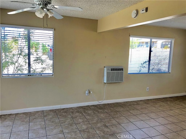 spare room featuring a wealth of natural light, a wall mounted air conditioner, and a textured ceiling