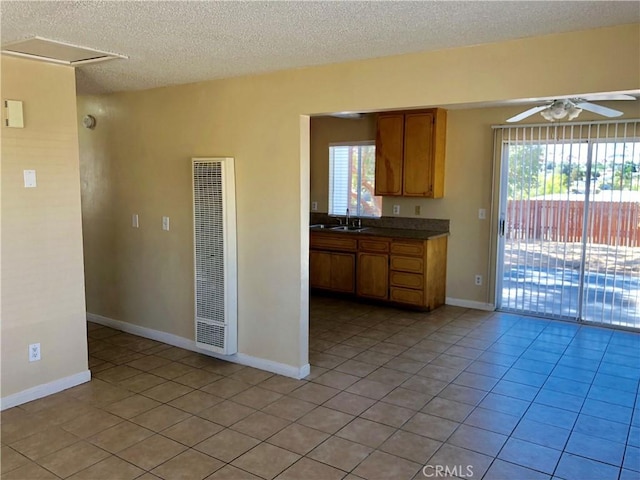 kitchen featuring ceiling fan, plenty of natural light, light tile patterned flooring, and sink