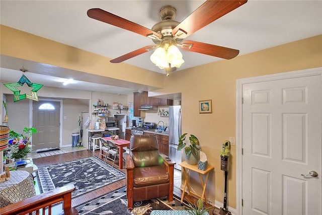 living room featuring hardwood / wood-style floors, ceiling fan, and sink