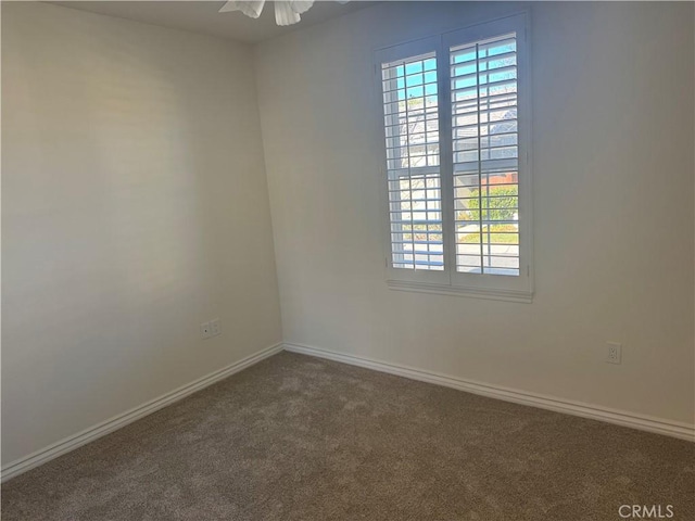 carpeted spare room featuring ceiling fan