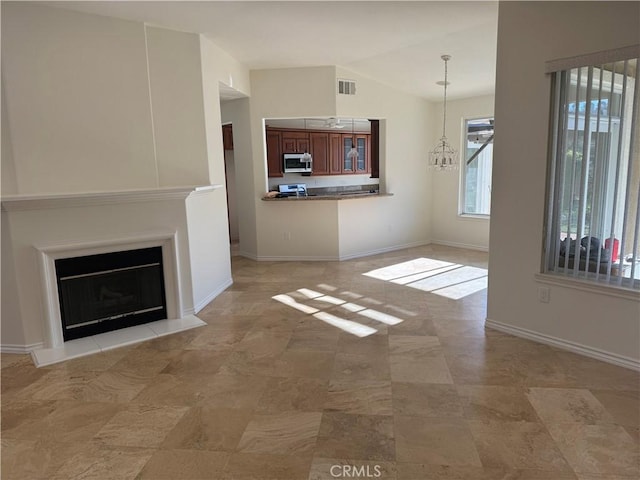 unfurnished living room with vaulted ceiling and an inviting chandelier