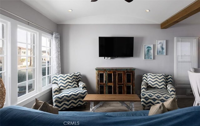 living room featuring wood-type flooring and vaulted ceiling with beams