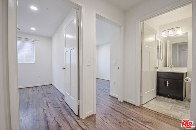 hallway featuring light hardwood / wood-style flooring and sink