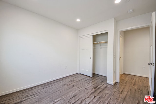 unfurnished bedroom with a closet and light hardwood / wood-style floors