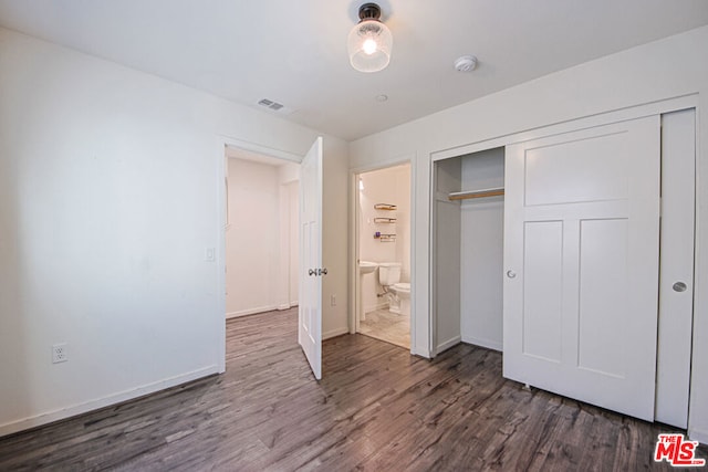 unfurnished bedroom featuring dark wood-type flooring and a closet