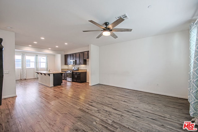 unfurnished living room with ceiling fan, sink, and dark hardwood / wood-style floors