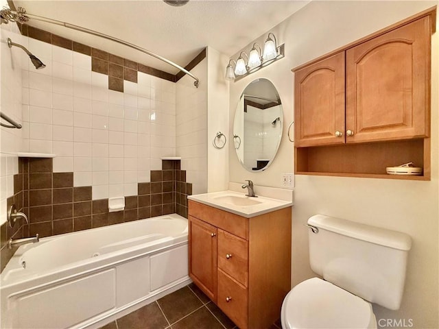 full bathroom featuring tile patterned floors, tiled shower / bath combo, toilet, and vanity