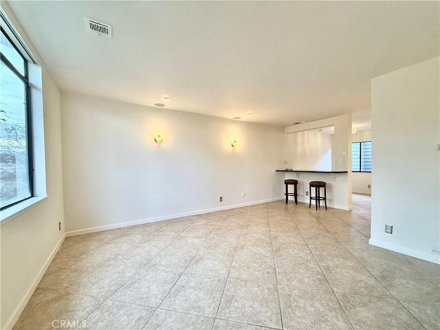 empty room with light tile patterned floors and a wealth of natural light