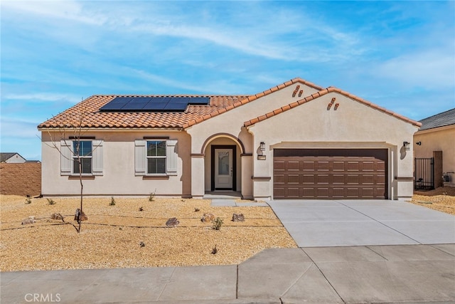 mediterranean / spanish house featuring solar panels and a garage