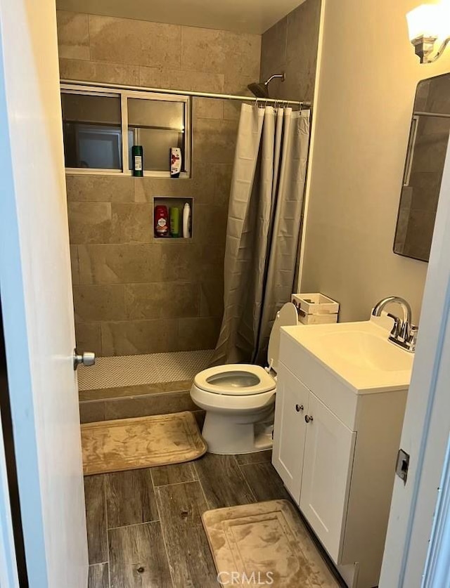 bathroom with toilet, vanity, and curtained shower