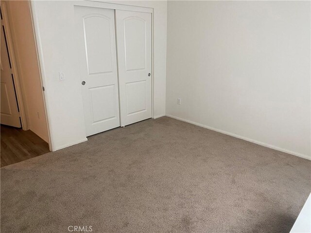 unfurnished bedroom featuring carpet floors and a closet