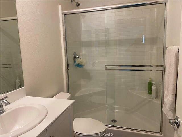 bathroom with vanity, toilet, and an enclosed shower