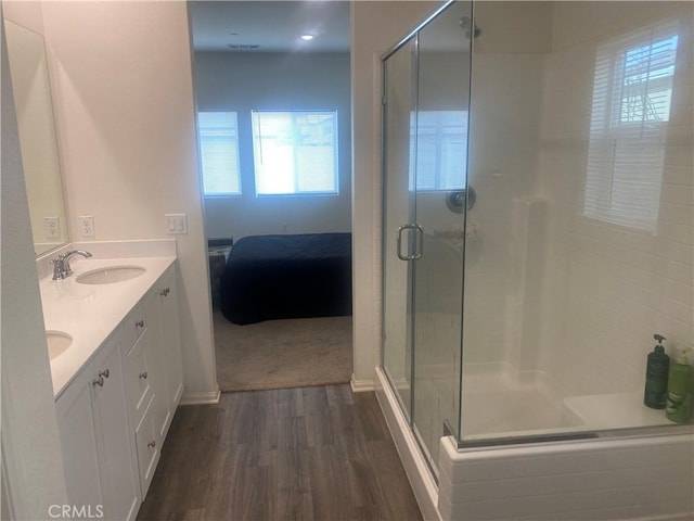 bathroom featuring hardwood / wood-style flooring, vanity, and a shower with door